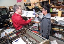 HELPING HAND: Dan Wood, owner and founder of DWRI Letterpress LLC print shop, works in 2008 with Lois Harada, shop manager, on the Polyman 50 automatic-fed cylinder letterpress at the shop’s headquarters in Providence.  PBN FILE PHOTO/MICHAEL SALERNO