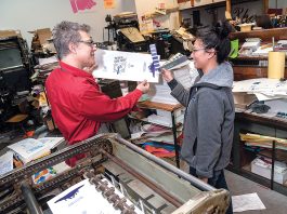 HELPING HAND: Dan Wood, owner and founder of DWRI Letterpress LLC print shop, works in 2008 with Lois Harada, shop manager, on the Polyman 50 automatic-fed cylinder letterpress at the shop’s headquarters in Providence.  PBN FILE PHOTO/MICHAEL SALERNO
