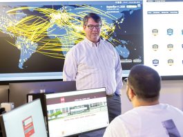 A DIFFERENT CLASSROOM: Douglas S. Alexander, director of the Institute for Cybersecurity & Emerging Technologies at Rhode Island College, speaks with RIC senior Miled Kalbourji in the institute’s cyber range classroom in 2025.  COURTESY RHODE ISLAND COLLEGE