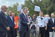 READY FOR BATTLE: Gov. Daniel J. McKee takes the podium as state and labor officials join forces in August 2025 to protest President Donald Trump’s effort to halt work on the Revolution Wind offshore wind farm.  PBN FILE PHOTO/MATTHEW MCNULTY
