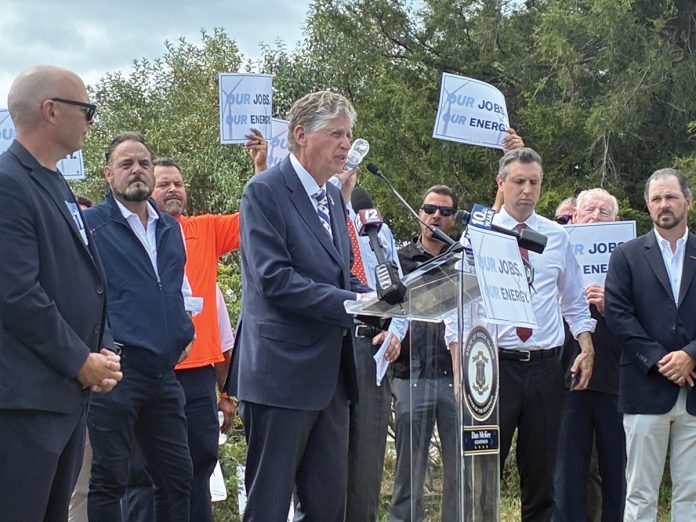READY FOR BATTLE: Gov. Daniel J. McKee takes the podium as state and labor officials join forces in August 2025 to protest President Donald Trump’s effort to halt work on the Revolution Wind offshore wind farm.  PBN FILE PHOTO/MATTHEW MCNULTY