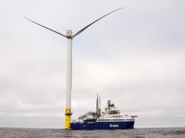 BACK AT IT:  An Orsted A/S vessel is docked to one of the massive wind turbines off the coast of Rhode Island. Work on the turbines was delayed because of Trump administration orders, but it has resumed after the courts stepped in.  AP FILE PHOTO/JOSHUA A. BICKEL