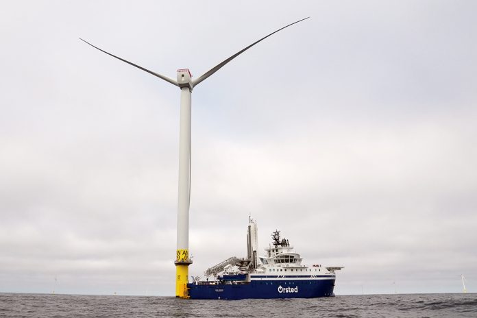 BACK AT IT:  An Orsted A/S vessel is docked to one of the massive wind turbines off the coast of Rhode Island. Work on the turbines was delayed because of Trump administration orders, but it has resumed after the courts stepped in.  AP FILE PHOTO/JOSHUA A. BICKEL