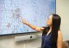 SPREADING OUT: University of Rhode Island public health professor Wenhui Feng examines a map of dollar stores in Rhode Island, most of them concentrated in urban areas. Feng is leading a new study on dollar stores and the food that is purchased there.  PBN PHOTO/STEPHANIE BERNABA