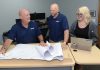Warwick AV firm goes global: Avidex FAR REACH: Avidex Industries LLC serves clients worldwide. From left, Bob Mathews, senior account executive; Thomas Ward, senior project manager; and Dominique Perrin, project coordinator, work on blueprints in Warwick.
PBN PHOTO /ELIZABETH GRAHAM