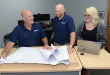Warwick AV firm goes global: Avidex FAR REACH: Avidex Industries LLC serves clients worldwide. From left, Bob Mathews, senior account executive; Thomas Ward, senior project manager; and Dominique Perrin, project coordinator, work on blueprints in Warwick.
PBN PHOTO /ELIZABETH GRAHAM