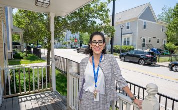 FIXER UPPER: Kate Dyl, Newport Heights property manager, stands on a townhouse porch in the affordable housing development in the North End of the city that’s about to undergo a phased-in renovation.  PBN PHOTO/DAVE HANSEN