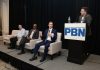 PBN Summit: R.I. businesses embracing AI but struggling to determine the payoff CHRISTOPHER PARISI, standing at right, founder and CEO of Trailblaze Marketing and vice chair of the Rhode Island AI Task Force, moderates a panel discussion during Providence Business News' 2026 Cybersecurity & AI Tech Summit on Thursday morning at the Crowne Plaza Providence-Warwick. Also on the panel, from right, are Seth Kolker, interim director of Rhode Island’s AI Hub; Arnell Milhouse, co-founder and CEO of yconic AI; and Robert Paradise, founder and CEO of Attain Technology. PBN PHOTO/MIKE SKORSKI