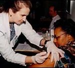 Flu shot administered by nurseMaria MacLellan to Lillian Almeidaat a Providence clinic.