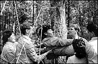 Co-workers depend on each otherto get through the Whispering Pines' rope course. Co-workers depend on each other<br>to get through the Whispering Pines'<br> rope course.