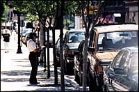 A Providence meter maid writes a<br>ticket for a parking violation. A Providence meter maid writes a<br>ticket for a parking violation.