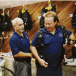 For scuba shop owner, water is a way of life Don Vierra helps Scuba Center employee DonLeedham try on a diving vest.
