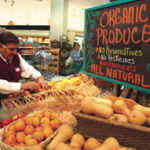Organic produce market adjusting An employee at East Side Marketplace in Providencearranges display of organic produce.