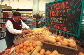 An employee at East Side Marketplace in Providencearranges display of organic produce. An employee at East Side Marketplace in Providence<br>arranges display of organic produce.