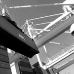 Proposed tariff elimination hailed by most R.I. leaders Worker at a container terminal in the Port of Oaklandwatches a crane load a cargo ship.