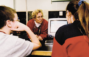 Gerry Burgess, center, offers advice and instructionin computer lab at Woonsocket Middle School. Gerry Burgess, center, offers advice and instruction<br>in computer lab at Woonsocket Middle School.