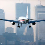 Airliner takes off at Logan International Airportoverlooking Boston skyline.