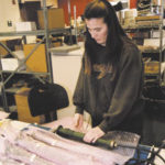 The business of war: Camouflage to cabinets, local firms supply troops A KVH Industries worker prepares productfor shipment.