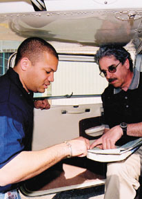 Alfred J. Mello Jr., right, reviews flightplans with flight instructor Scott McCoy. Alfred J. Mello Jr., right, reviews flight<br>plans with flight instructor Scott McCoy.