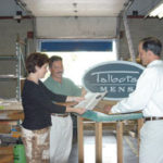 Mandeville Sign executives Jeanne, James and TomMandeville inspect a sign made at their company.