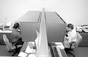Dan Caiani, left, and Debra Sage work in adjoiningcubicles at Alga Plastics in Cranston. Dan Caiani, left, and Debra Sage work in adjoining<br>cubicles at Alga Plastics in Cranston.