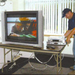 Consumers tuning into high-definition TV Bill Potter of Cox Communications wires a televisionand other equipment for high-definition.