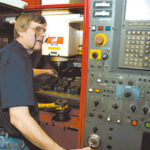 Ron Turcotte calibrates a machine at TotalManufacturing in Slatersville.