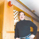 Dave Lombardi, of The 1025 inJohnston, stands below his recentlyinstalled fire alarm.