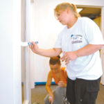Jillian Sullivan, kneeling, and Amanda Young, both Koch Eye Associates, paint a room at the Rhode Island Mentoring Partnership in Warwick as part of Koch's volunteer work. 