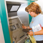 Lisa Regan, of Cumberland, withdraws her card from an ATM at Warwick Mall. 