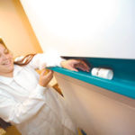 Sorlina Cruz, a pharmacy technician trainee at the West Warwick Thundermist health center, demonstrates a new drug dispensing process. The state received four drug dispensing machines for area health centers.
