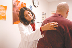 <b>Photo by Frank Mullin</b>Dr. Sophia Gandhi examines a patient at the R.I. Free Clinic, where more than 1,300 uninsured adults receive care and the staff mainly consists of volunteers. <b>Photo by Frank Mullin</b><br>Dr. Sophia Gandhi examines a patient at the R.I. Free Clinic, where more than 1,300 uninsured adults receive care and the staff mainly consists of volunteers.