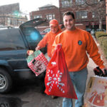 R.I. Resource Recovery employees Mark Vierra, front, and Alan Gelfuso deliver donated toys to DCYF for its holiday donation program.