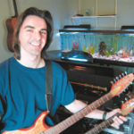 Photo by Frank MullinTony Ricci in his Woonsocket recording studio, which is equipped with such "toys" as several guitars, a grand piano, an old Wurlitzer keyboard - and of course his fish tank.