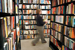 <b>Photo by Frank Mullin</b>Anne Marie Keohane, co-owner of Symposium Books on Westminster Street in Providence, walks among the stacks, restocking shelves at the downtown bookstore, which carries about 10,000 titles. <b>Photo by Frank Mullin</b><br>Anne Marie Keohane, co-owner of Symposium Books on Westminster Street in Providence, walks among the stacks, restocking shelves at the downtown bookstore, which carries about 10,000 titles.