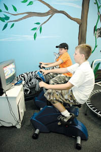 <b>A NEW SPIN:</b> Matthew Walkow, left, 10, and his brother Jacob, 12, ride bikes linked to a PlayStation 2 game system. <b>A NEW SPIN:</b> Matthew Walkow, left, 10, and his brother Jacob, 12, ride bikes linked to a PlayStation 2 game system.