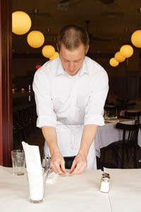 PBN photo/Stephanie Ewens
<b>Michael Wiseman,</b> 24, who works as a server at Red Stripe, a bistro on the East Side of Providence, resets tables after the lunch rush. PBN photo/Stephanie Ewens<br><br>
<b>Michael Wiseman,</b> 24, who works as a server at Red Stripe, a bistro on the East Side of Providence, resets tables after the lunch rush.