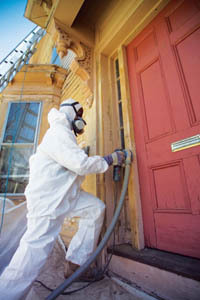 <b>A WORKER</b> in protective gear removes lead paint from a house in Pawtucket. / <b>A WORKER</b> in protective gear removes lead paint from a house in Pawtucket. /