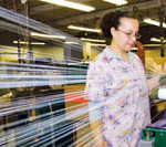 PBN photo/Stephanie Ewens
Maria Corey, a worker at Metlon Corp. in Cranston, puts reflective yarn on spools that will then be sent to companies that make athletic apparel and other items. 