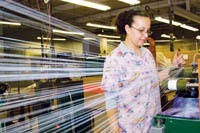 PBN photo/Stephanie Ewens
<b>Maria Corey</b>, a worker at Metlon Corp. in Cranston, puts reflective yarn on spools that will then be sent to companies that make athletic apparel and other items. PBN photo/Stephanie Ewens<br><br>
<b>Maria Corey</b>, a worker at Metlon Corp. in Cranston, puts reflective yarn on spools that will then be sent to companies that make athletic apparel and other items.