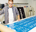 PBN Staff photo/Stephanie Ewens 
Tim Brown prepares U.S. Women's Open signs by applying the printed vinyl sheets to magnets at Signs by Tomorrow in Warwick.