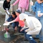 Photo courtesy The Compass School
Making water work: Students at The Compass School test a water-powered carousel they built. Crouching around the carousel are, from left, sixth-graders Megan Martin and Maddie Zeek and eighth-grader Sean Donoghue.