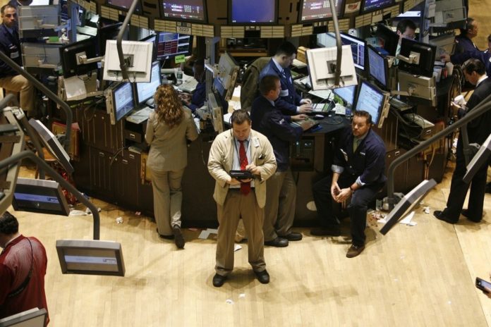 TRADERS WORK the floor of the New York Stock Exchange yesterday, when 'extraordinary heavy trading' erased this year's gains and caused problems with Dow Jones, NYSE and Nasdaq data reporting. / TRADERS WORK the floor of the New York Stock Exchange yesterday, when 'extraordinary heavy trading' erased this year's gains and caused problems with Dow Jones, NYSE and Nasdaq data reporting. /