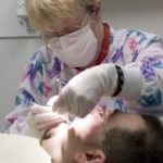 Expanding dental services<br> for northern R.I.’s poor DENTAL HYGIENIST Mary O?Connor works on a patient at Blackstone Valley Community Health Care, which is building a much larger dental facility nearby. /