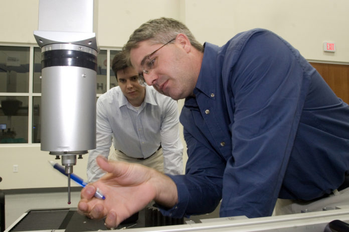 HEXAGON METROLOGY employees Frank Krazer, left, and Scott Everling test a coordinate measuring machine at the company's headquarters in North Kingstown. / HEXAGON METROLOGY employees Frank Krazer, left, and Scott Everling test a coordinate measuring machine at the company's headquarters in North Kingstown. /