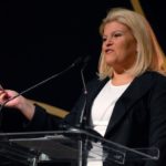 TORY JOHNSON, founder and CEO of the recruitment service Women For Hire, offers the crowd a $100 bill to show how timid women can be about taking what they want. / 