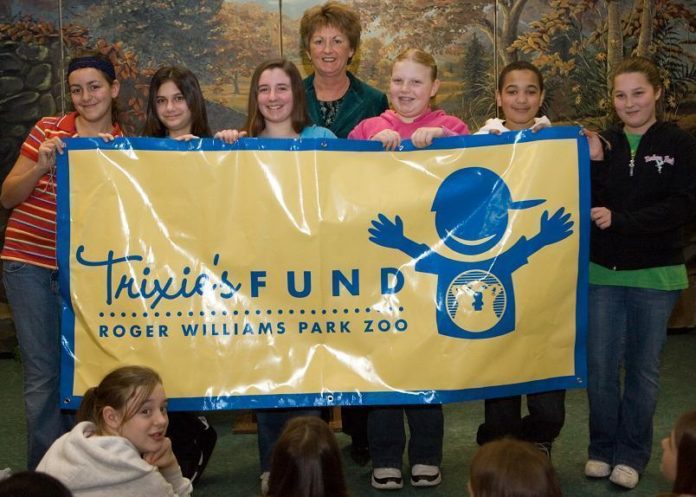 LILLIAN MCGEE, from Verizon, spends time with students from West Warwick?s Deering Middle School during their Trixie?s Fund-sponsored field trip to the Roger Williams Park Zoo. / 