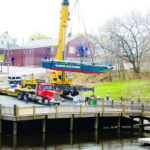 A CRANE drops the Blackstone Valley Explorer in the water in Central Falls. The boat is used for tours highlighting the region?s history and natural beauty. / 