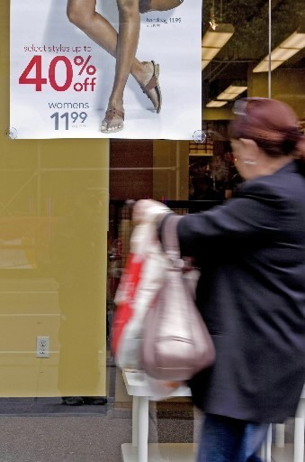 SPENDING by U.S. consumers continued to rise faster than incomes last month, pushing the U.S. personal savings rate to a negative 1.4% as consumers spent $139.8 billion more than they earned. Above, a shopper checks out the sale sign at a shoe store in the Big Apple. / SPENDING by U.S. consumers continued to rise faster than incomes last month, pushing the U.S. personal savings rate to a negative 1.4% as consumers spent $139.8 billion more than they earned. Above, a shopper checks out the sale sign at a shoe store in the Big Apple. /
