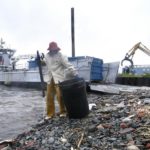 Out of the water, at long last CLEAN THE BAY staffer Dave Tobler removes debris during the cleanup last Monday. /